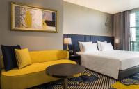 a hotel room with a bed and a couch at Chatrium Hotel Riverside Bangkok in Bangkok