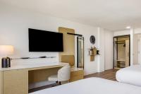 a hotel room with a desk and a tv at Hotel Preston Nashville Airport in Nashville