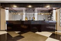 a lobby with a bar with three yellow objects on it at Hotel Preston Nashville Airport in Nashville