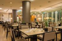 a dining room with tables and chairs and windows at HF Fénix Lisboa in Lisbon