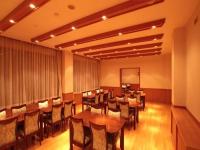 una sala da pranzo con tavoli e sedie in legno di Resort Project Myoko Kogen Hot Spring a Myoko