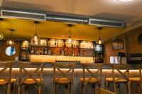 un bar con taburetes de madera en un restaurante en Hotel Sebas 202, en Caracas