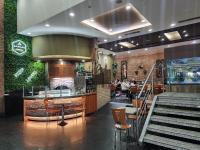 Un restaurante con un bar y algunas personas sentadas en mesas. en Hotel Sebas 202, en Caracas