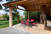 Un patio con mesa y sillas y una chimenea. en Queens cottage, en Shumen