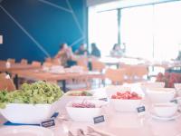 a table with bowls of fruits and vegetables on it at Blue Rabbit Hotel in Chanthaburi