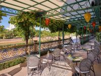 um pátio com mesas, cadeiras e lanternas em Hotel Royal Hoi An Danang em Hoi An