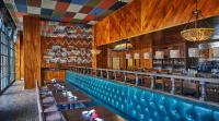 a restaurant with wooden walls and a bar with tables at Graduate by Hilton Iowa City in Iowa City