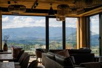 a living room with couches and a view of mountains at The Pines Bucegi Lodge in Bran