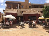 un gruppo di persone seduti ai tavoli di fronte a un edificio di Casa Blanco Espana - Hacienda del Alamo a Murcia