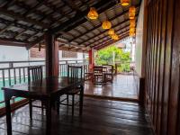uma sala de jantar com uma mesa e cadeiras num alpendre em Vientiane Ruby Villa Hotel em Vientiane