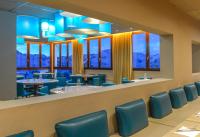 a restaurant with blue chairs and tables and windows at Villages Clubs du Soleil - LES 2 ALPES in Les Deux Alpes