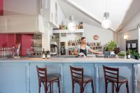 マコンにあるイビス バジェット マコン シュードの4脚の椅子があるバーの後ろに立っている男性