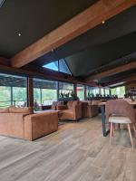 Una sala de estar con sofás, mesas y ventanas. en Grand Chamois Hotel & Spa, en Mavrovo