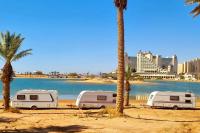 drei Wohnwagen neben Palmen am Strand in der Unterkunft Caravan In the Desert in Eilat