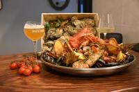 a plate of seafood on a table with a glass of wine at Elegant Grand Place Stays in Brussels
