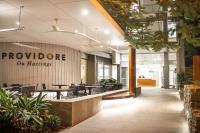 a lobby of a building with tables and chairs at Netanya Noosa Beachfront Resort in Noosa Heads