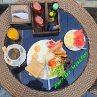 a table with a plate of breakfast food on it at Chiang Mai Waroros Boutique Hotel in Chiang Mai