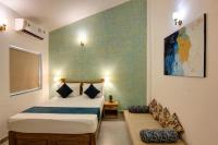 a bedroom with two beds and a chair in it at Comfort Holiday Home in Baga