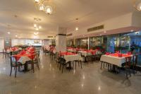 um restaurante com mesas e cadeiras vermelhas e brancas em MinaMark Beach Resort for Families and Couples Only em Hurghada