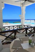 een tafel en stoelen met uitzicht op de oceaan bij Sosua Ocean Village in Sosúa