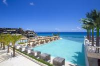 een zwembad met stoelen en de oceaan op de achtergrond bij Sosua Ocean Village in Sosúa