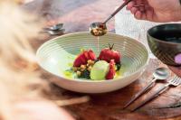 una persona comiendo un tazón de fruta con una cuchara en Delfins Beach Resort Bonaire, Tapestry Collection by Hilton, en Kralendijk