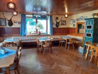 um restaurante com pisos e mesas e cadeiras de madeira em Gasthof Zur Alten Post em Hinterschmiding