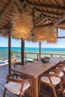 Bahia MaracaiboにあるMonasterio del Vientoの木製テーブルと椅子(ビーチデッキに設置)