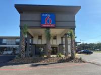 un hotel con palmeras frente a un edificio en Studio 6 Alvin, TX, en Alvin