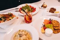 a white table with plates of food on it at Riga Islande Hotel with FREE Parking in Rīga