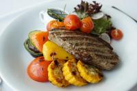 a white plate of food with meat and vegetables at Riga Islande Hotel with FREE Parking in Rīga