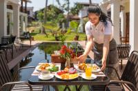 a woman preparing a tray of food on a table at Elegant Boutique Hotel Luangprabang in Luang Prabang