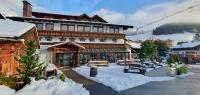 Un gran edificio con nieve delante. en Hotel Edelweiẞ garni - b&amp;b, en Berwang