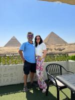Un hombre y una mujer posando para una foto frente a las pirámides. en Solima pyramids inn, en El Cairo