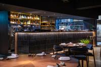 um restaurante com duas mesas e um bar em The Blue by Just Inn em Taipei