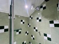 a shower with black and white tiles in a bathroom at Espaço Verano - Suíte Master 2 in Niterói