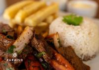 a plate of food with rice and meat and vegetables at Hoteles Paraiso PIURA in Piura