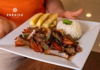 a plate of food with meat and french fries and rice at Hoteles Paraiso PIURA in Piura