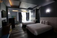 ein Hotelzimmer mit zwei Betten und einem Fernseher in der Unterkunft Days Inn &amp; Suites by Wyndham Milwaukee in Milwaukee