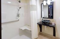 ein Badezimmer mit Waschbecken und Spiegel in der Unterkunft Days Inn &amp; Suites by Wyndham Milwaukee in Milwaukee