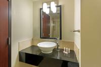 ein Badezimmer mit Waschbecken und Spiegel in der Unterkunft Days Inn &amp; Suites by Wyndham Milwaukee in Milwaukee