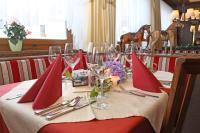 una mesa con servilletas rojas y copas de vino. en Landgasthof Kaiserkrone, en Elmen