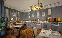 una grande cucina con tavolo e cibo di The College Green Dublin Hotel, Autograph Collection a Dublino