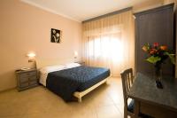 Un dormitorio con una cama y un jarrón de flores. en Villa Hotel Del Sole, en Chiusi