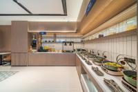 広州市にあるEcharm Hotel Guangzhou Baiyun Station Julong Metro Stationの大きなキッチン(多くの皿を用意)