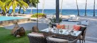 einen Tisch und Stühle mit Meerblick im Hintergrund in der Unterkunft Atmosphere Resorts & Spa in Dauin