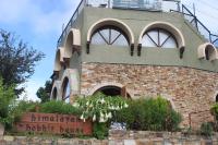 Un edificio de ladrillo con un balcón en la parte superior. en Himalayan Hobbit House, en Almora