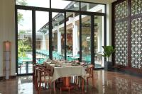 Un comedor con mesa y sillas y ventanas. en SBH Gloria Hue, en Hue