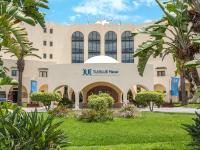 Un edificio con palmeras delante. en TUI BLUE Manar, en Hammamet