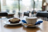un cupcake et une tasse de café sur une table dans l'établissement Pastoral Lodge at the Sanctuary of the Divine Mercy, à Cracovie